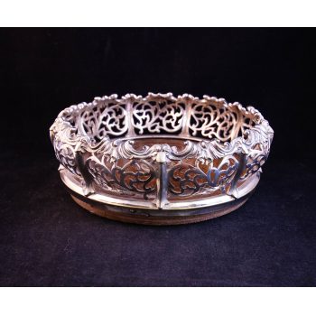 Ornate silver plated bottle coaster with mahogany base. Measures 7.5"W x 3"H